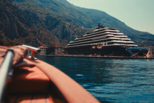 A luxury handmade boat cruising through Kotor Bay’s calm waters.